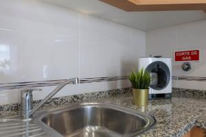 a kitchen counter with a sink and a coffee pot at Chez Oasis Lagos - Charming Central by the Beach in Lagos