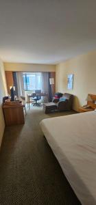 a hotel room with a bed and a living room at Sol Alphaville Flat completo lazer cama casal in Barueri