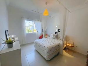 a white bedroom with a bed and a window at Duplex,near the Beach plus airport in Punta Cana +46 photos
