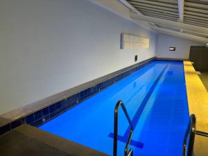 ein großer Pool mit blauem Wasser in einem Gebäude in der Unterkunft Resort Style Studio in Auckland
