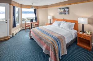 a hotel room with a bed and a table and chairs at Land's End in Homer