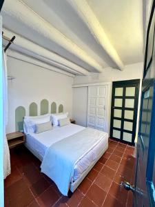 a bedroom with a large white bed in a room at Casa Ande Hotel boutique in Villa de Leyva
