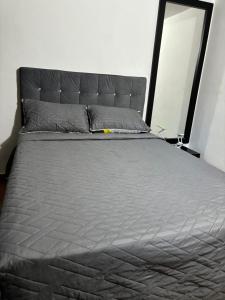a large bed in a bedroom with a gray mattress at Apartamento en Bello (Medellín) in Bello