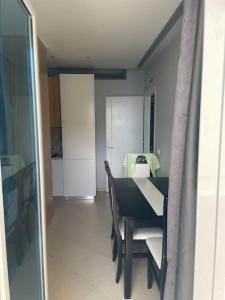 a dining room with a black and white table and chairs at 2 Bedroom flat Shengjin in Margjonaj