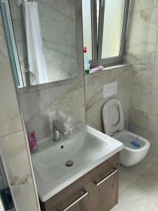 a bathroom with a sink and a toilet at 2 Bedroom flat Shengjin in Margjonaj