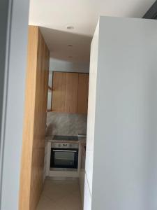 a kitchen with wooden cabinets and a stove top oven at 2 Bedroom flat Shengjin in Margjonaj