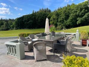 a patio with a table and chairs and an umbrella at Muckross Riding Stables in Killarney