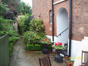a garden with flowers in pots next to a brick building at Beverley Budget Inn in Beverley
