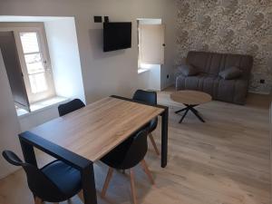 a living room with a table and chairs and a couch at Chez David - Vacances sous les toits in Brioude
