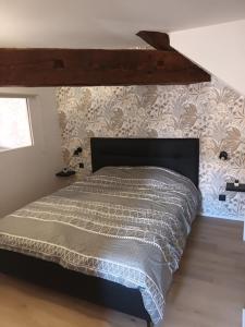 a bedroom with a large bed with a wooden headboard at Chez David - Vacances sous les toits in Brioude
