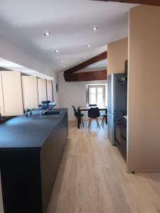 a large kitchen with a counter and a dining room at Chez David - Vacances sous les toits in Brioude