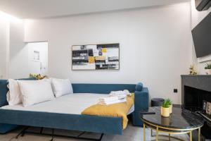 a living room with a blue couch and a fireplace at Laskaris Luxury Apartment in Kalamata
