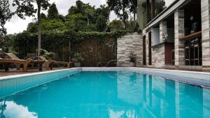a swimming pool with blue water in front of a house at Villa Maritaca Condomínio de 4 Casas de Locação por Temporada de Alto Padrão com SPA in Arraial d'Ajuda +228 photos