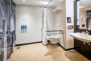 a bathroom with a toilet and a sink and a shower at Radisson Blu Hotel, Hamburg Airport in Hamburg
