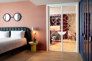 a bedroom with a bed and a sliding glass door at art'otel London Battersea Power Station, Powered by Radisson Hotels in London