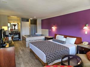 a hotel room with a bed and a bath tub at Fullerton Inn in Fullerton