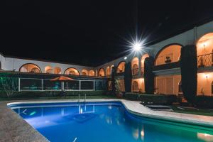 a swimming pool in a building at night at Hotel & Suites Villa del Sol in Morelia