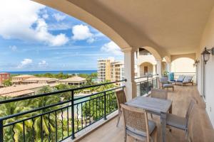 a balcony with a table and chairs and a view of the ocean at Designers Delight 3 BR w Pool Gym Tennis Courts in Cupecoy