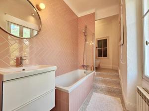 a bathroom with a tub and a sink and a mirror at POOL, Panoramic VIEW Authentic Village Villa in Saint-Jeannet