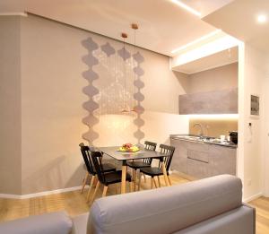 una cucina e una sala da pranzo con tavolo e sedie di BURNÌA Sicily Holiday House a Palermo