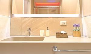 un lavandino da bagno con specchio sopra di BURNÌA Sicily Holiday House a Palermo