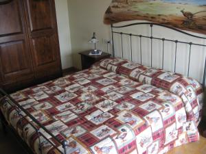 a bed with a quilt on it in a bedroom at La Valle in Nervesa della Battaglia