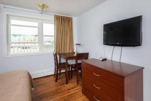a hotel room with a desk and a television at Marguerite Motel in Hampton