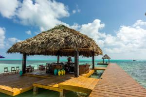 a wooden pier with a restaurant on the beach at X'tan Ha- The Waterfront in San Pedro