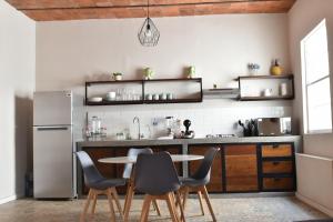 a kitchen with a table and chairs and a refrigerator at CASAS FREDA - Centro Historico Departamentos in San Luis Potosí