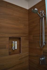 a bathroom with a shower with wooden walls at CASAS FREDA - Centro Historico Departamentos in San Luis Potosí