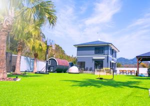 a yard with a house and a playground at itotoi別邸-サウナ&プール&広々ドッグラン付きペットと泊まれる極上ヴィラ in Itoshima