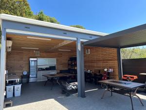 an outdoor patio with a table and a kitchen at itotoi別邸-サウナ&プール&広々ドッグラン付きペットと泊まれる極上ヴィラ in Itoshima