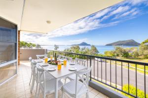 une table à manger sur un balcon avec vue sur l'océan dans l'établissement Albacore 6, à Nelson Bay