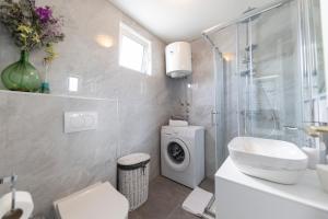 a bathroom with a sink and a washing machine at Puntamika studio in Zadar +18 photos