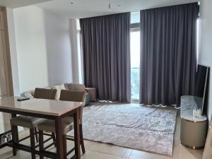 uma sala de estar com uma mesa e um sofá em Coco em Ghantoot