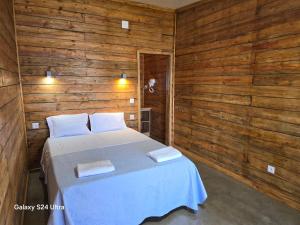 a bedroom with a bed in a wooden wall at COMPORTA SIDE - Lake in Setúbal