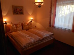 ein Schlafzimmer mit einem Bett mit Kissen und einem Fenster in der Unterkunft Mairhofer in Bischofshofen