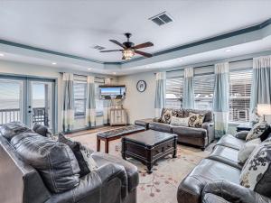 a living room with leather furniture and a ceiling fan at Shore Better Than Work in Rockport