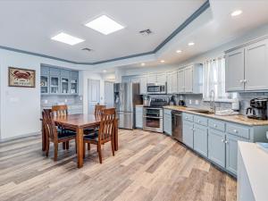 a large kitchen with a wooden table and chairs at Shore Better Than Work in Rockport