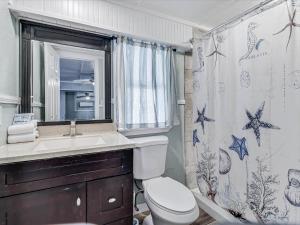 a bathroom with a toilet and a sink and a mirror at Shore Better Than Work in Rockport +29 photos