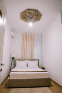 a bedroom with a bed and a ceiling at Vila Franko in Berat