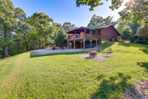a house on a hill with a large yard at Just a Cast Away Cassville Cabin with Covered Deck in Cassville