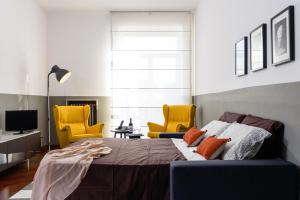1 dormitorio con 1 cama y 2 sillas amarillas en ALTIDO Lovely Apt with Terrace and View in Central Milan, en Milán