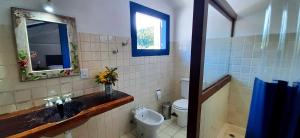 a bathroom with a sink and a toilet and a mirror at Casa Beira Rio in Paraty