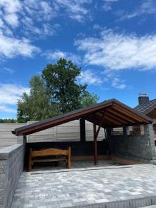 a pavilion with a wooden bench on a patio at Słoneczne ranczo Zator Energylandia in Zator