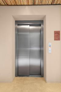 een grote metalen liftdeur in een gebouw bij KAHATSA' boutique hotel in Tulum