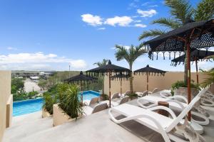 een patio met witte stoelen en een zwembad bij KAHATSA' boutique hotel in Tulum
