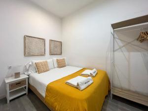 a bedroom with a bed with a yellow blanket at Stay U-nique Apartments Rossello in Barcelona