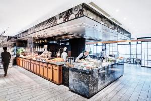 a kitchen with people preparing food in a restaurant at The Strings Hotel Nagoya in Nagoya