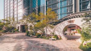a stone path in front of a building with tall buildings at 苏州山塘街华贸姑苏里酒店公寓 in Suzhou